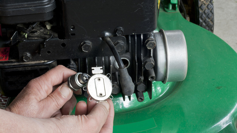 Spark plug gap tool on lawnmower engine