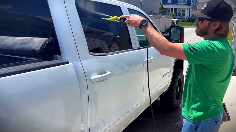A man using the Ryobi EZ-Clean Squeegee on a pickup