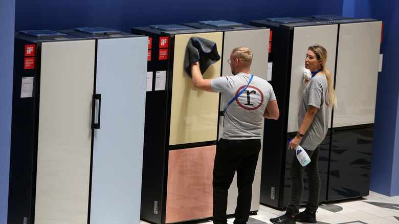 People checking out Samsung refrigerators.