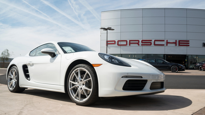 Porsche 718 in front of a brand outlet.