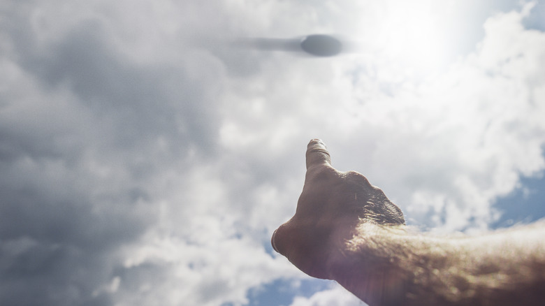 Hand pointing at a UFO