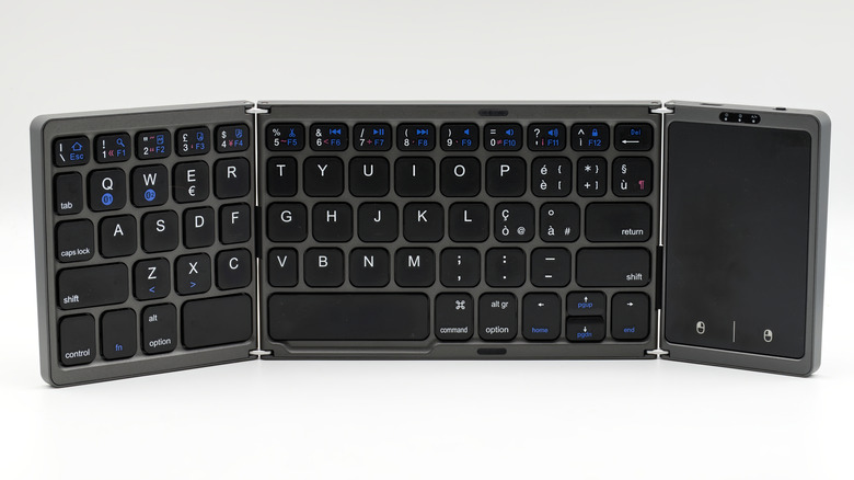 A gray and black tri-fold foldable keyboard with with a touchpad against a white background