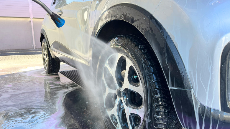 A car being washed, close up on wheel.
