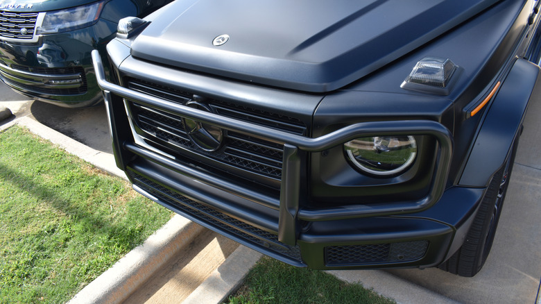 Close-up of a truck's front end with a grill guard mounted over the grill and headlights