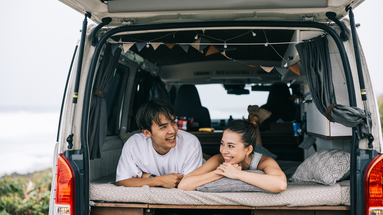 A couple in a bed in a camper van.