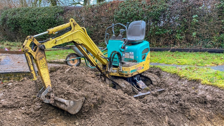 A mini excavator is stuck in the mud.