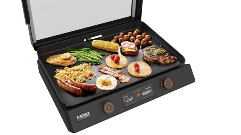 assorted foods cooking on Blackstone electric griddle
