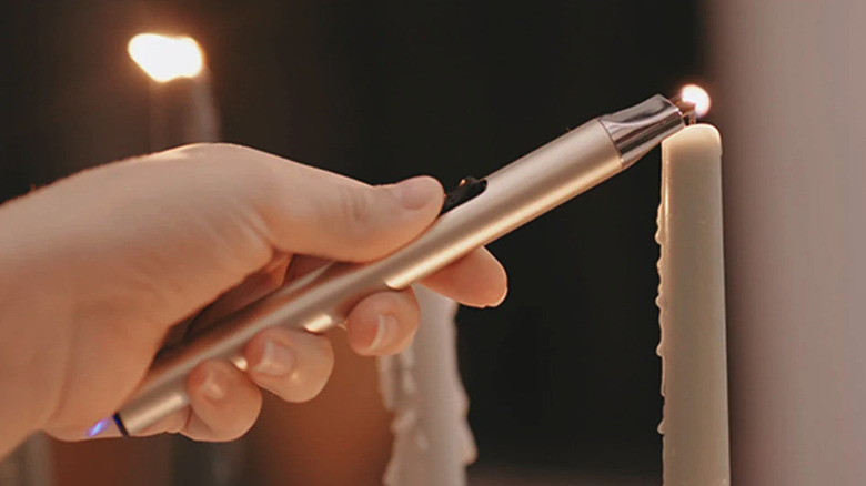 Person lighting a candle using the Reidea USB electric lighter