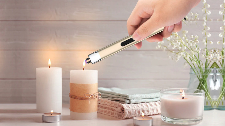 Person lighting a candle using the Reidea USB electric lighter
