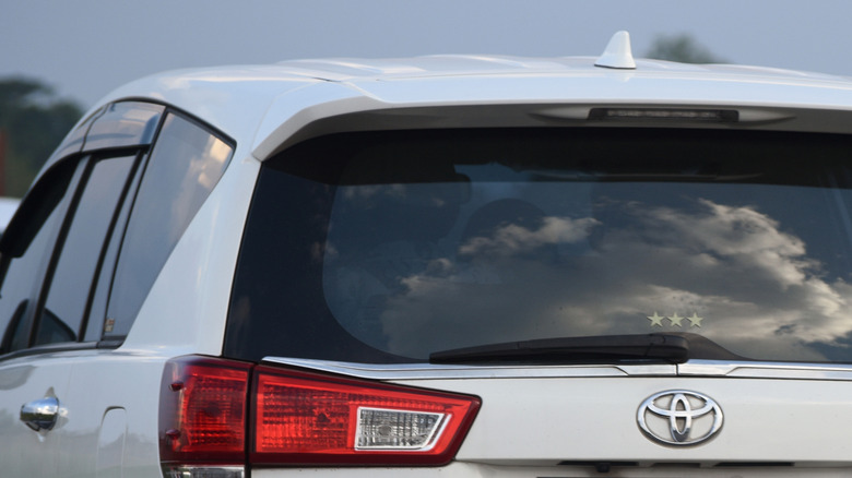Rear shot of a white Toyota Kijang Innova Reborn with shark fin antenna