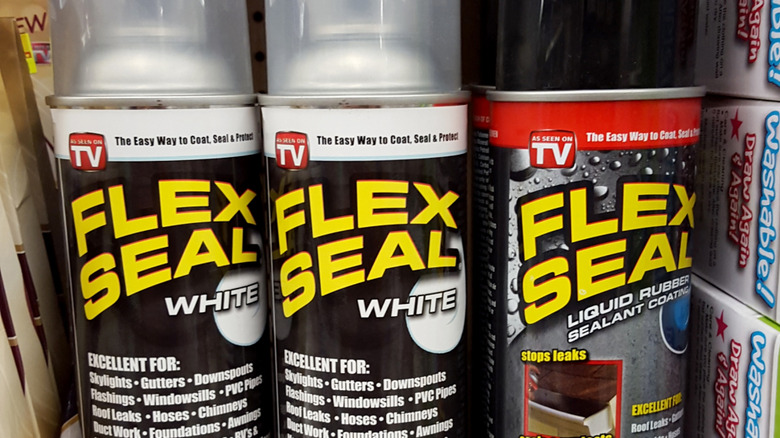 Close-up of three Flex Seal cans, two white and one black