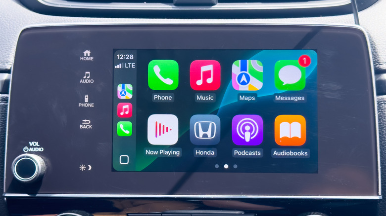 an infotainment screen, prominently featuring Apple CarPlay with various app icons,