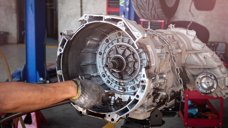 Mechanic working on transmission in shop