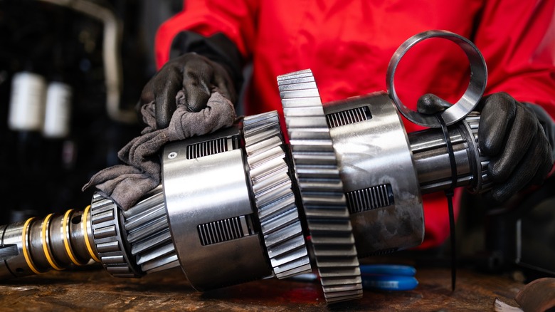 Mechanic servicing transmission on workbench