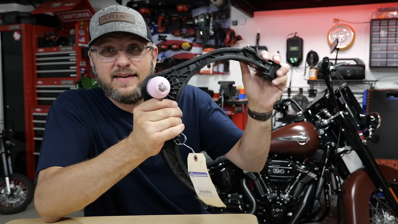 Man holding up a Ram 1500 control arm