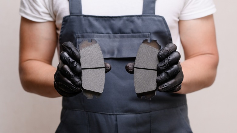 close up of a man holding brake pads