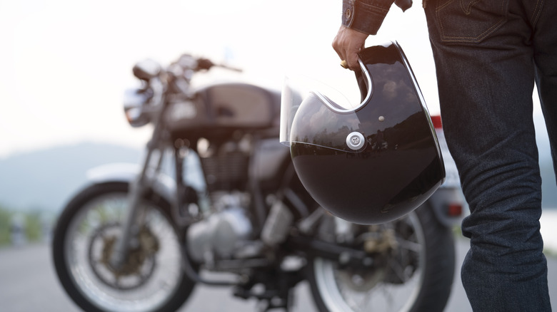 person holding motorcycle helmet