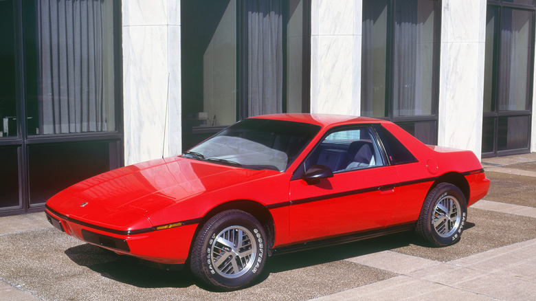 Red Pontiac Fiero on display in front of building