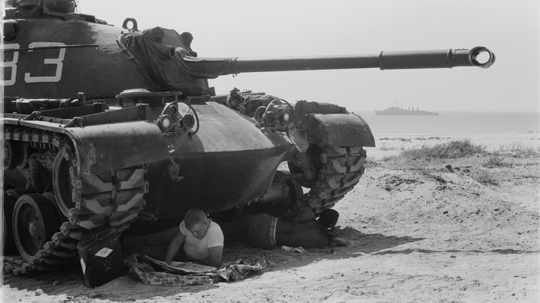 Soldiers in shade of M48 tank
