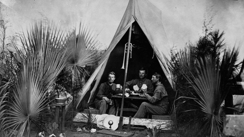 Black and white photo of Civil War soldiers eating in tent
