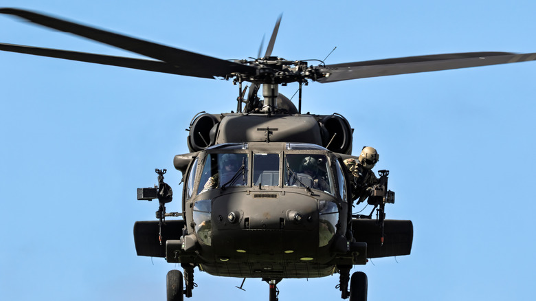 Frontal view of a UH-60 Black Hawk helicopter flying through clear blue skies