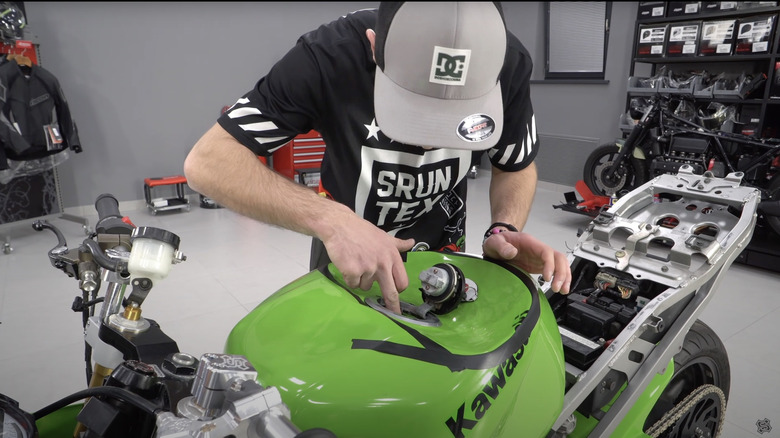 Man denting gas tank of sports bike
