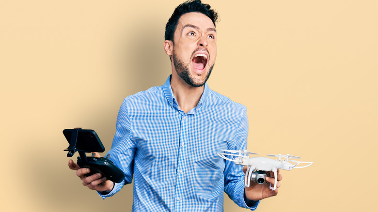 Man angrily holding on to drone