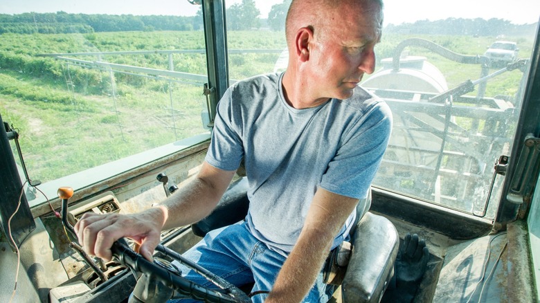 Farmer looking back at sprayer from tractor cab
