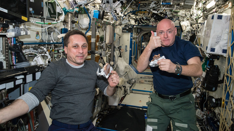 NASA astronaut Scott Kelly and Russian cosmonaut Mikhail Kornienko eating a snack on the ISS