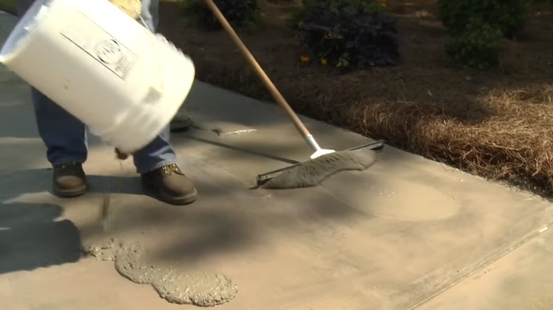 concrete being poured and spread on a driveway