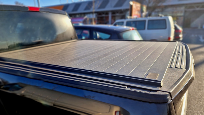 Pickup truck bed with lockable tonneau cover