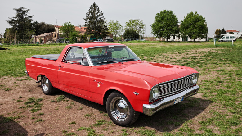 Red Ford Ranchero parked in a field
