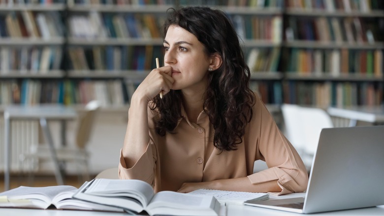 A person with books and laptops.