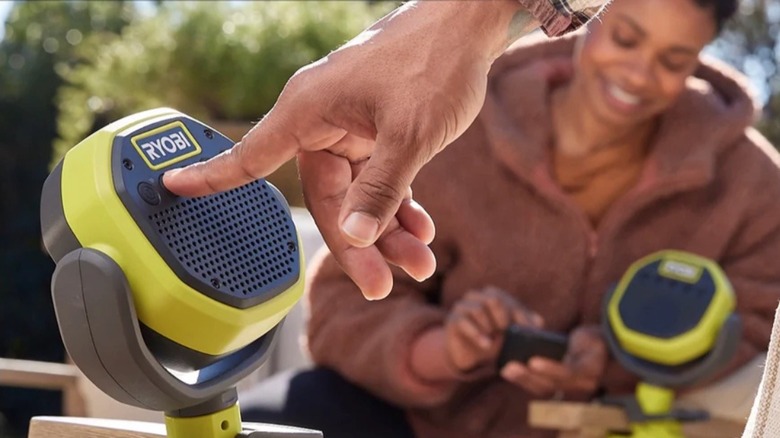 Person adjusting controls on Ryobi Clamp Speaker