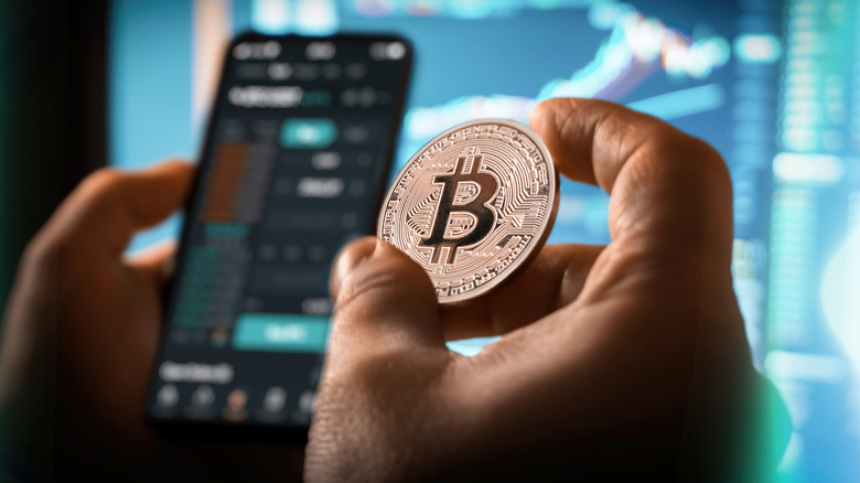 Bitcoin held in hand with smartphone