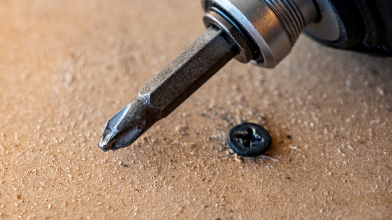 A screw with a stripped head and a damaged Phillips bit.