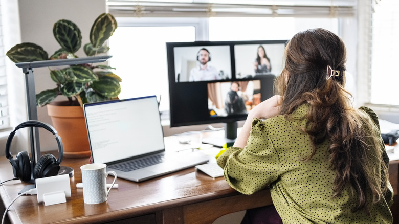 Rear view of woman having a video call on a second monitor