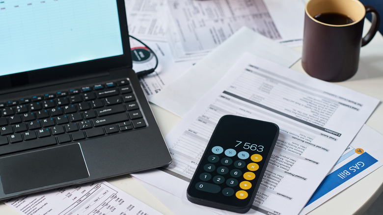 Closeup of smartphone, laptop and paperwork on desk