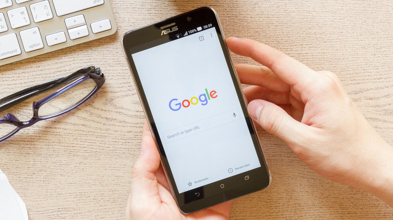 hand holding smartphone using google