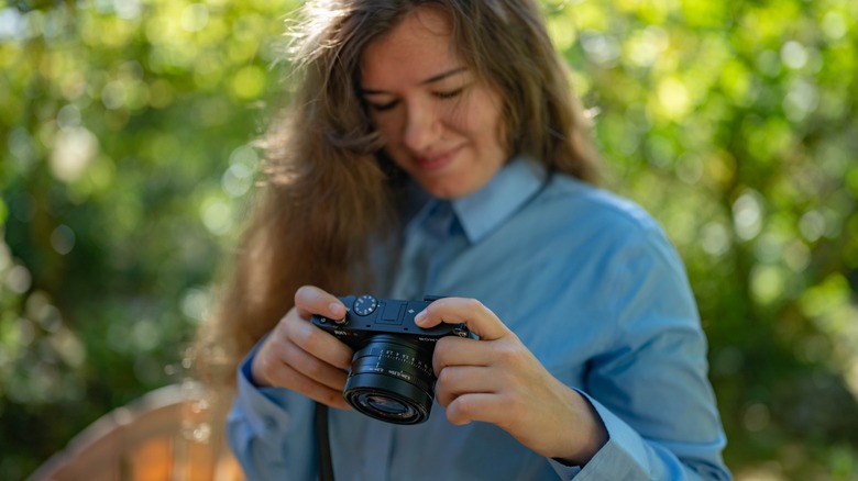 A woman reviewing photos on the Sony RX1R iii.