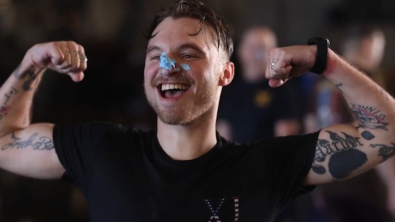 A sailor with blue nose celebrating with arms flexed