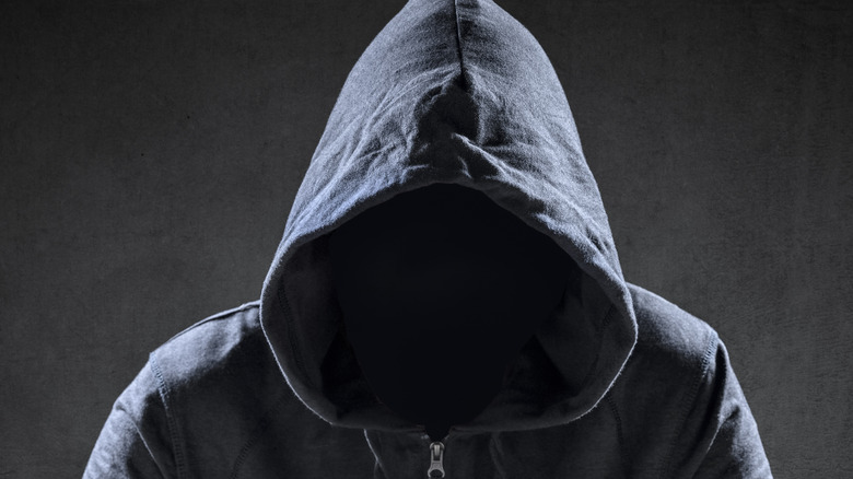 hooded figure at laptop