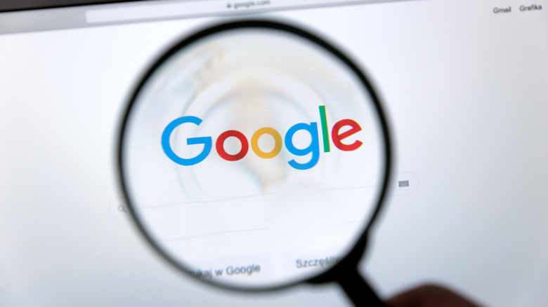 Looking at a Google logo through magnifying glass