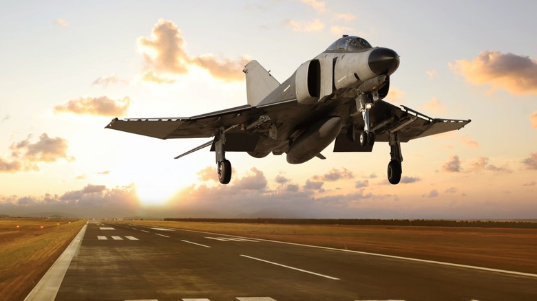 F-4 family fighter jet above runway