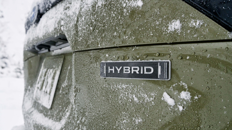 Close up of Hybrid badge on an olive Subaru Forester.
