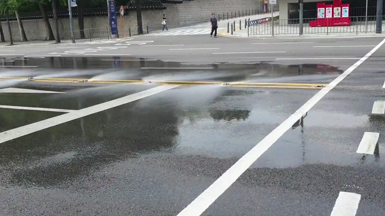 road studs alongside road dividers spraying water to cool down the temperature