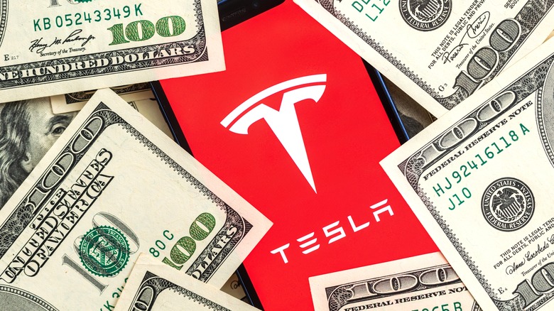Tesla logo surrounded by dollar bills