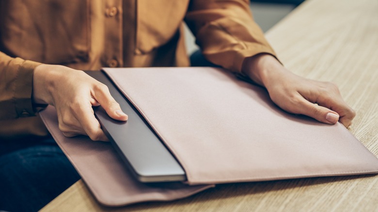  woman taking her laptop pc out of the bag 