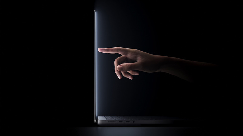 Person interacting with the touchscreen MacBook Pro.
