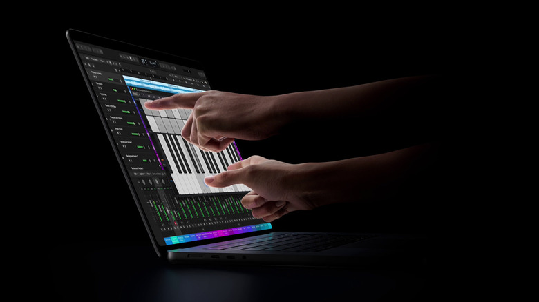 Person playing a virtual piano on the MacBook Pro's screen.